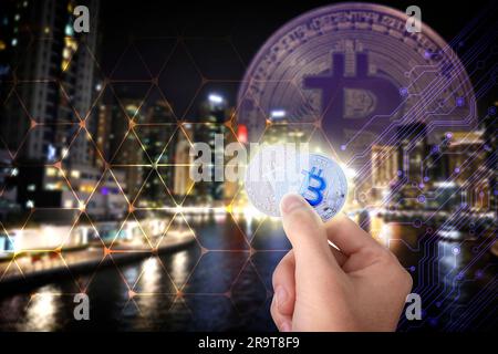 Man holding bitcoins against digital scheme and cityscape, closeup Stock Photo
