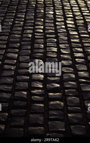 Black cobblestone pavement in the evening Stock Photo