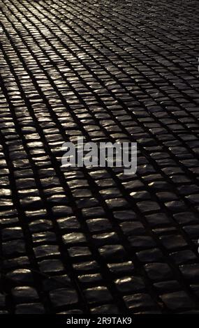 Black cobblestone pavement in the evening Stock Photo