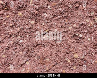 Closeup of a rough surface and textured red background of an uneven brick Stock Photo