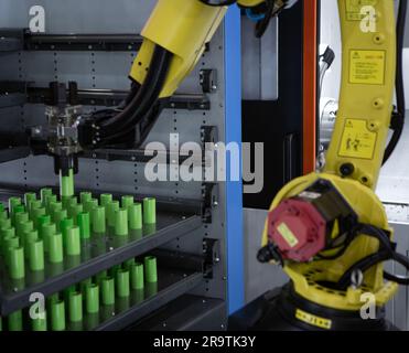 Automated manufacturing process. Robot arm loading workpieces on CNC lathe machine. Stock Photo