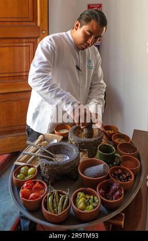Chef preparing a traditional Pasilla Chili Sauce with all traditional mexican ingredients from Oaxaca. Stock Photo