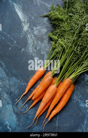 Fresh carrots with leaves on blue background Stock Photo