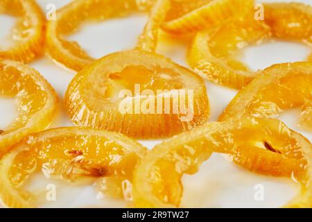 Citrus zest: Roasted lemon wedges on a white plate in a bright kitchen. Stock Photo