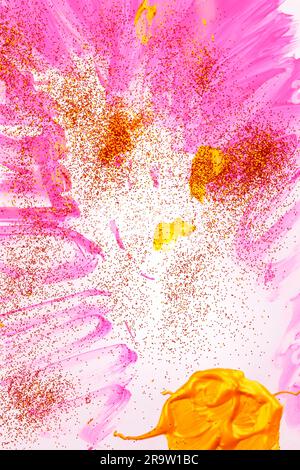 On a white background, pink streaks of watercolor are sprinkled with gold sparkles. Stock Photo