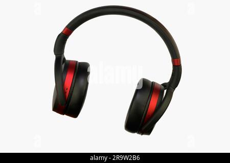 Wireless stereo headset. Black and red cordless headphones. Earphones isolated on white background with clipping path. Macro horizontal image, close-u Stock Photo