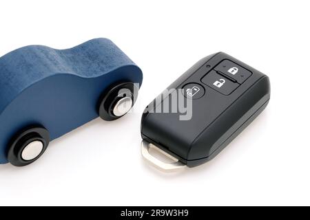 Car black key remote controller and small toy car on white background Stock Photo