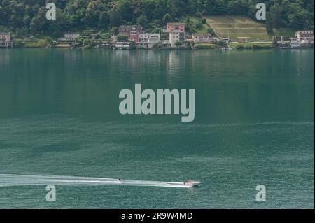 Aerial view of a water ski motorboat on Lake Lugano, with Brusino Arsizio in the background, Switzerland Stock Photo