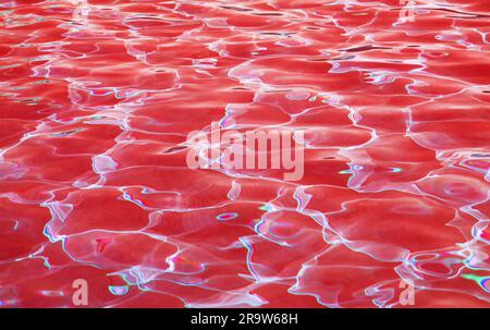 Eye-catching surreal pop art of red colored water surface reflecting with sunlight for abstract background Stock Photo