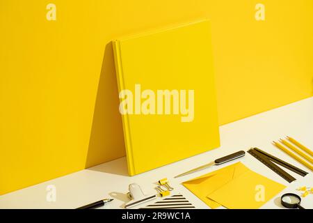 Yellow blank hardcover book and stationary mockup, template on yellow and white background. Stationary flat lay, back to school Stock Photo