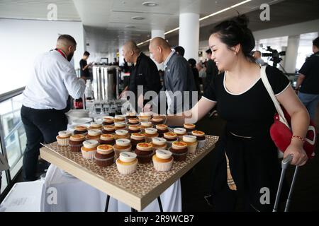 Zaventem, Belgium. 28th June, 2023. A passenger takes a cupcake at the Brussels Airport in Zaventem, Belgium, June 28, 2023. A ceremony was held for China's Hainan airlines at Brussels Airport on Wednesday to mark the resumption of its Brussels-Shenzhen direct flights. Credit: Zheng Huansong/Xinhua/Alamy Live News Stock Photo