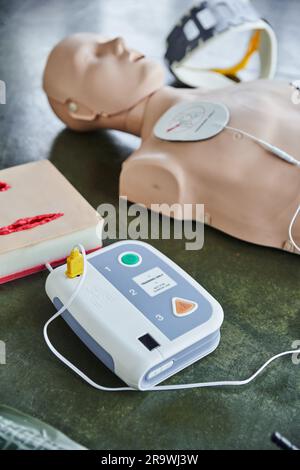 CPR training manikin near automated external defibrillator, wound care ...