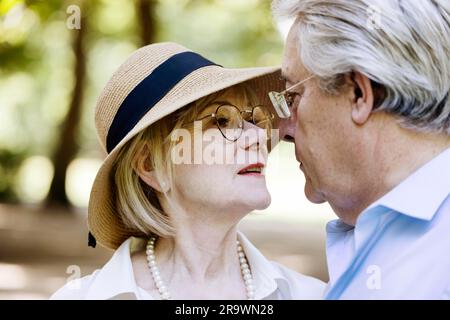 Summery dressed older woman together with her grey-haired man in the park, portrait, Cologne, North Rhine-Westphalia, Germany Stock Photo