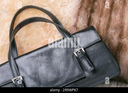 A black leather bag of warm blond sheepskin, blue fox and red sable mink furs Stock Photo