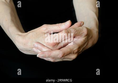 Different positions of senior woman's hands on black background Stock Photo
