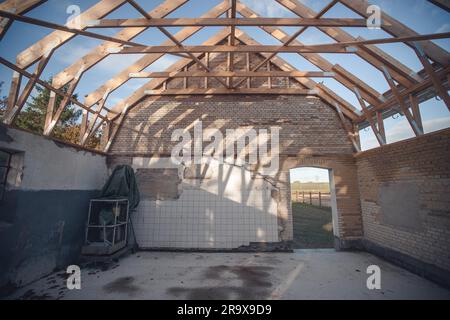 Home improvement on an old building missing the roof and weathered walls with tiles and grunge blue paint Stock Photo