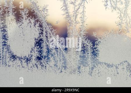 Frozen window in the winter on a cold morning with frost patterns on the glass Stock Photo