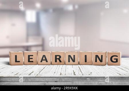 Learning in a classroom with a sign on a wooden table in a bright room Stock Photo