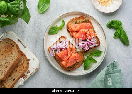 Sandwiches with salted salmon, avocado guacamole, red onions and basil. Smorrebrod. Set of danish open sandwiches. Healthy food, breakfast. Clean eati Stock Photo