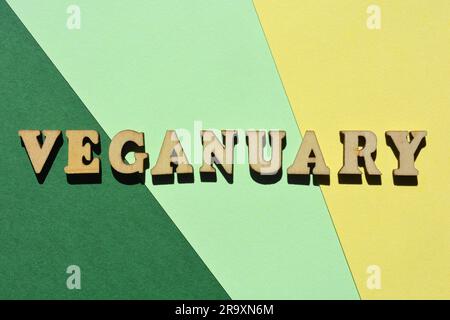 Veganuary, word in wooden alphabet letter isolated on green and yellow background Stock Photo