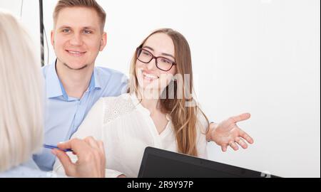 The psychologist conducts a session with his patients in the office, gives them advice about their life. A young couple consults a psychologist doctor Stock Photo