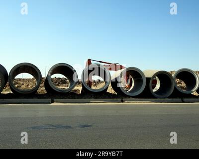 Cairo, Egypt, June 24 2023: A digging excavator for preparations of large water pipe parts in place, sanitation pipes, improvement of infrastructure a Stock Photo