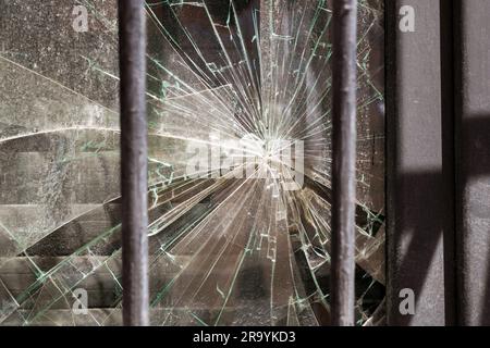 Broken shattered glass behind the window bars. Criminal hacking concept Stock Photo
