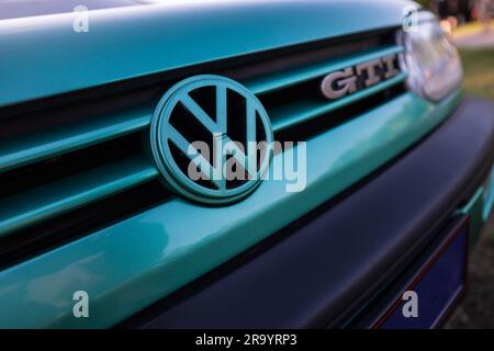 Berlin, Germany - June 24, 2023: Volkswagen logo on a Volkswagen GTI car at a meadow. Stock Photo