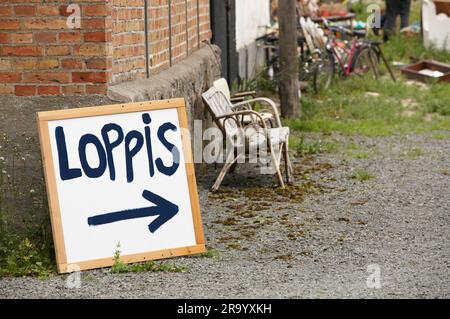 Signboard on ground against bricked structure arrowing toward the flee market. Sweden. Stock Photo