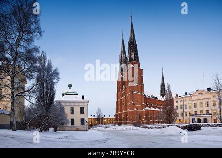 The cathedral against clear blue sky with snow covered landscape in the foreground. Uppsala, Sweden. Stock Photo