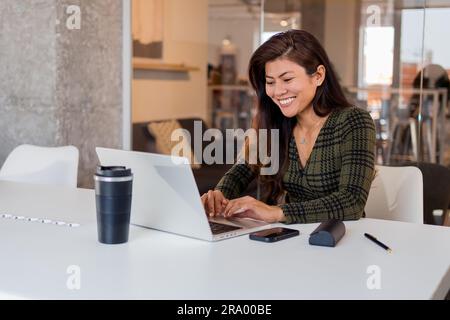 Smiling woman working on laptop