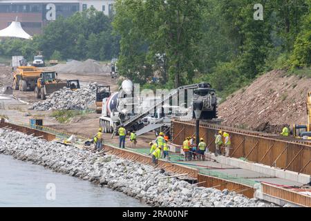 Detroit, Michigan - Workers pour cement to complete a section of the Detroit Riverwalk on the site of the former Uniroyal tire factory. The walking/bi Stock Photo
