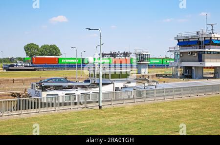 Stuw- en sluizencomplex Sambeek, Netherlands - July 9. 2023: Maas river sluis with inland waterway cargo container ship Stock Photo