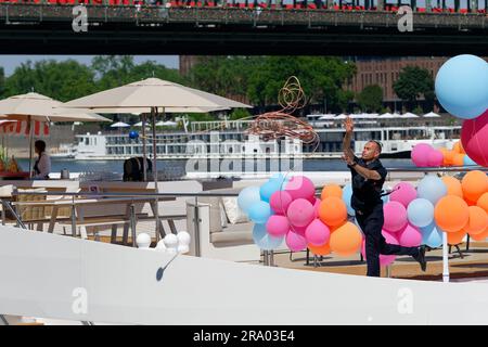 cologne, germany, june 29 2022: a river cruise ship prepares to dock on the rhine in front of cologne's old town with colorful balloons welcoming new Stock Photo