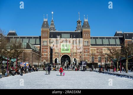 Family and kids walking on the snow towards the Rijksmuseum, Amsterdam, Netherlands Stock Photo