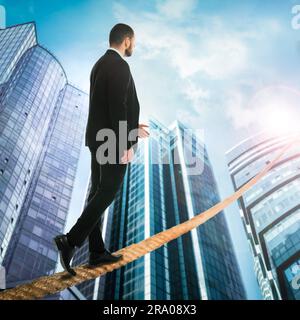 Risks and challenges of entrepreneurship. Businessman walking on rope leading to top Stock Photo