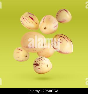 Fresh ripe pepino melons falling on yellow green background Stock Photo