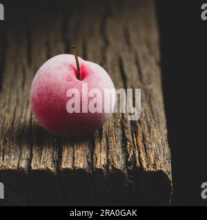 delicious plum on old wood and dark background Stock Photo