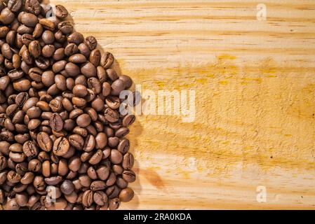 Background with coffee beans and light wood texture Stock Photo