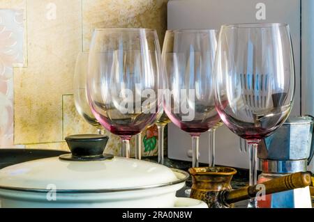 Dirty empty wine glasses and a white pot, after a good dinner, are waiting to be washed Stock Photo