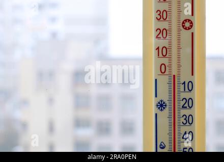 A thermometer, fixed out of the window, shows that it is zero degree celsius outdoor, while it is warm inside the room Stock Photo