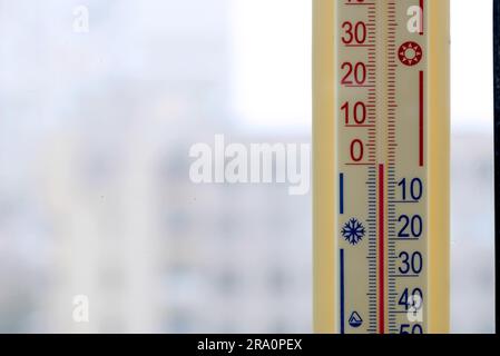 A thermometer, fixed out of the window, shows that it is zero degree celsius outdoor, while it is warm inside the room Stock Photo