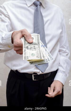 Corrupted businessman, or politician, offering a Dollar banknotes bribe Stock Photo