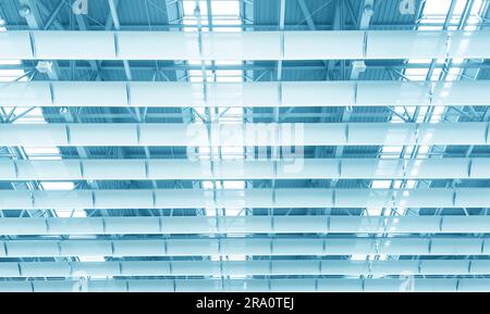Lights and ventilation system in long line on ceiling of the  industrial building. Exhibition Hall. Blue ceiling factory construction Stock Photo