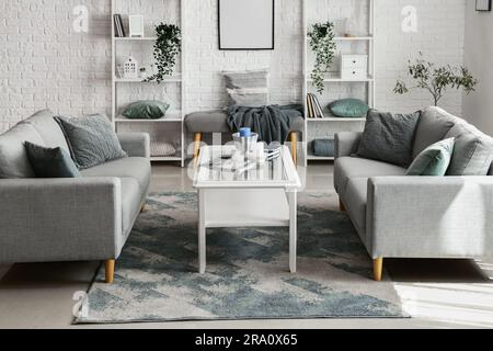 Interior of light living room with cozy grey sofas and coffee table Stock Photo