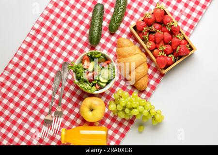 Bowl with salad, tasty food and juice for picnic on white background Stock Photo