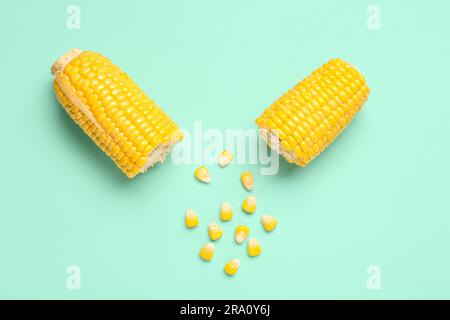 Cut fresh corn cobs and seeds on turquoise background Stock Photo