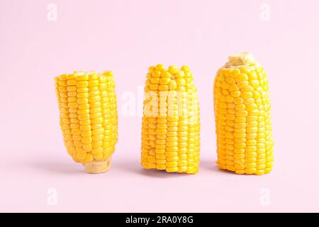 Cut fresh corn cobs on pink background Stock Photo