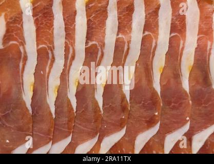Jamon serrano. A Spanish ham texture background. Traditional spanish jamon sliced. Dry cured meat ham. Hamon iberico Stock Photo