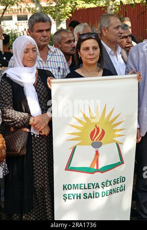 Diyarbakir, Turkey, 29/06/2023, A Kurdish woman holds a pennant of the Sheikh Said association during the memorial ceremony for the Kurdish leader Sheikh Said and his friends, who were executed 98 years ago Kurdish leader Sheikh Said and 46 of his friends were commemorated on the 98th anniversary of their execution, at the place where they were executed in Diyarbakir. Kasim Firat, President of the Association and grandson of Sheikh Said, Saliha Aydeniz, Co-Chairman of the Democratic Regions Party (DBP), members of the Green Left Party (YSP) and Peoples' Democratic Party (HDP), representatives  Stock Photo
